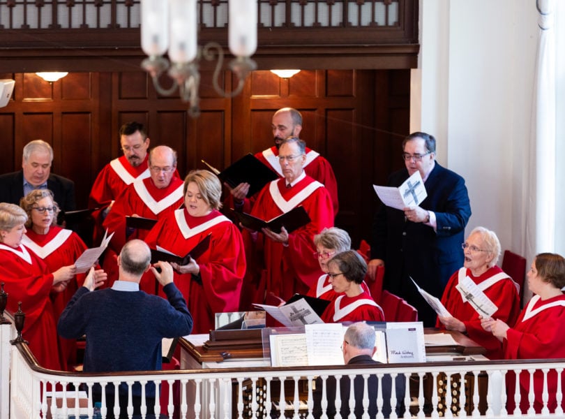 The adult choir sings in worship