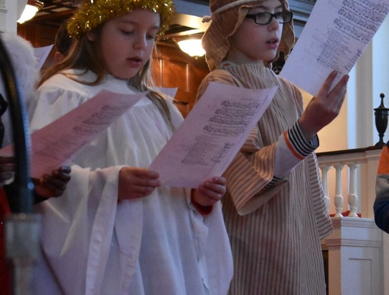Two youth dressed as an angel and a shepherd sing during the Christmas Eve worship service