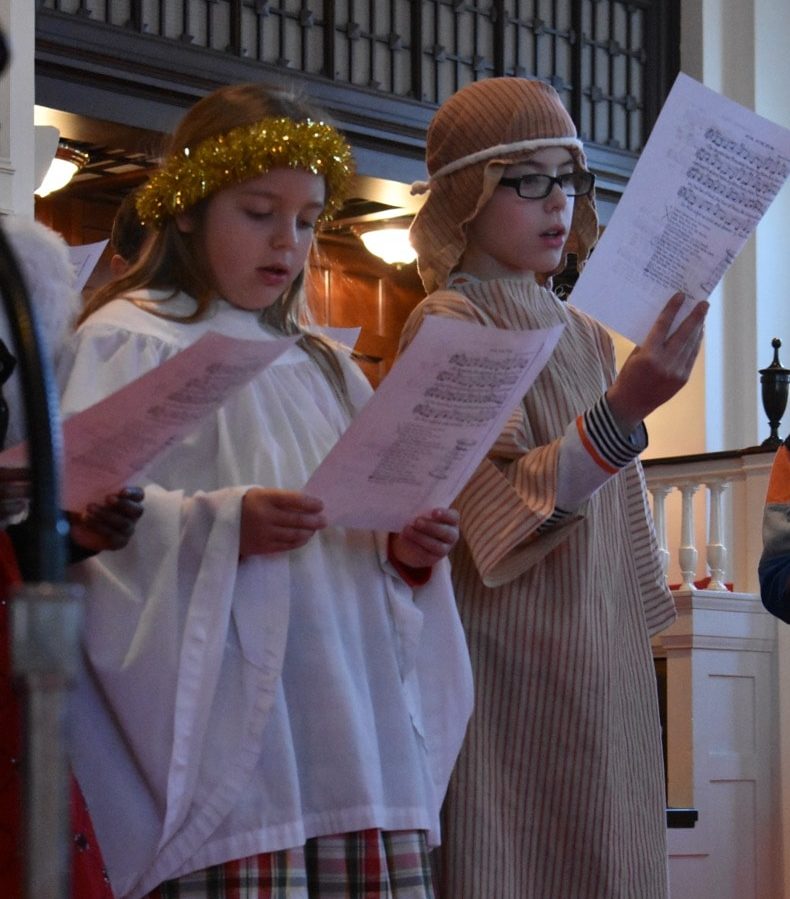 Two youth dressed as an angel and a shepherd sing during the Christmas Eve worship service