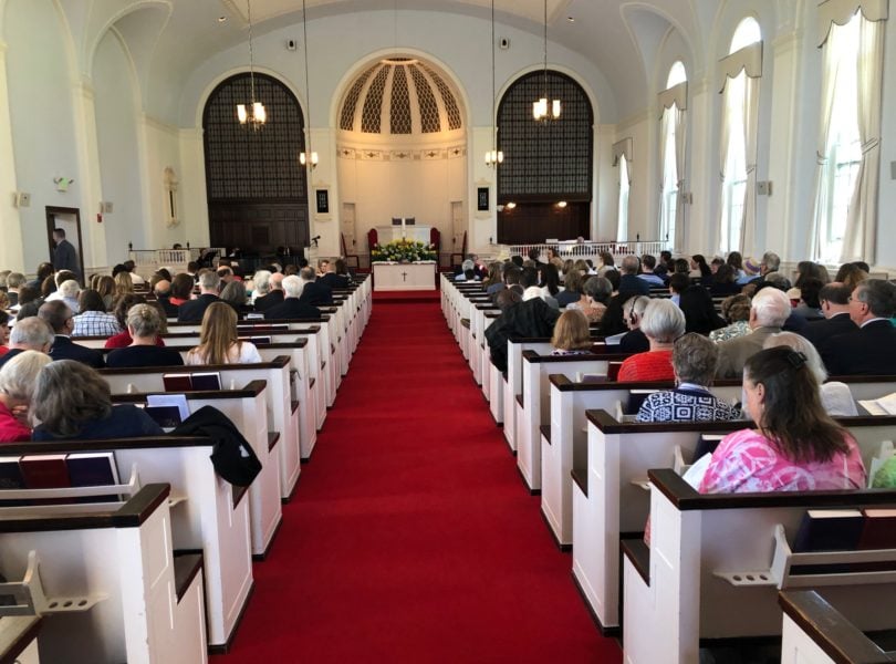 A view of people in worship from the back of the sanctuary