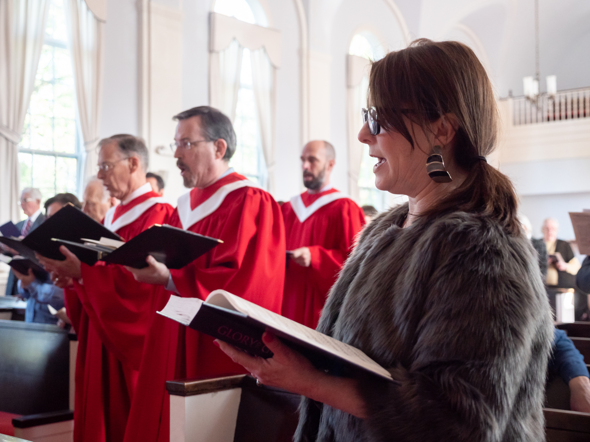 Choir members singing in red robes