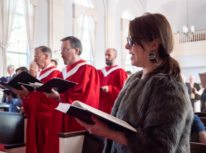 Choir members singing in red robes