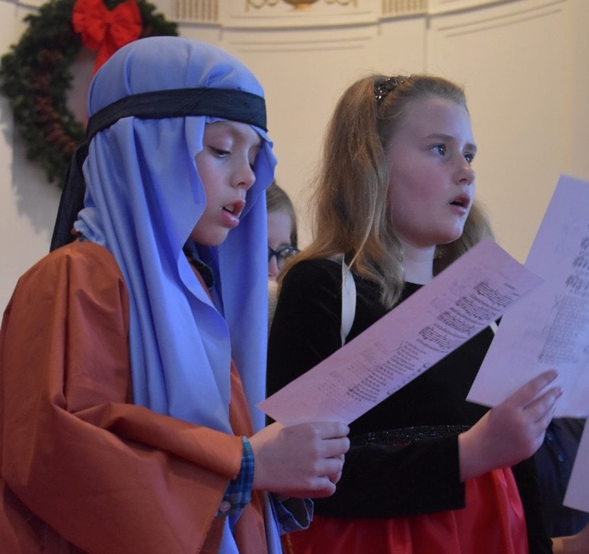 Two youth sing during the Christmas Eve worship service