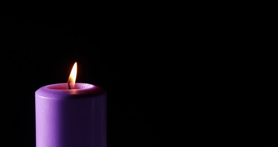 A single purple candle is lit against a black background