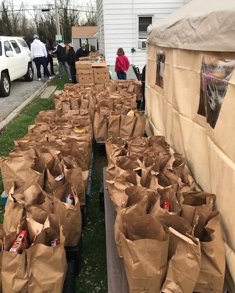 Brown paper bags filled with food are lined up awaiting distribution at the Grace AME food drive.