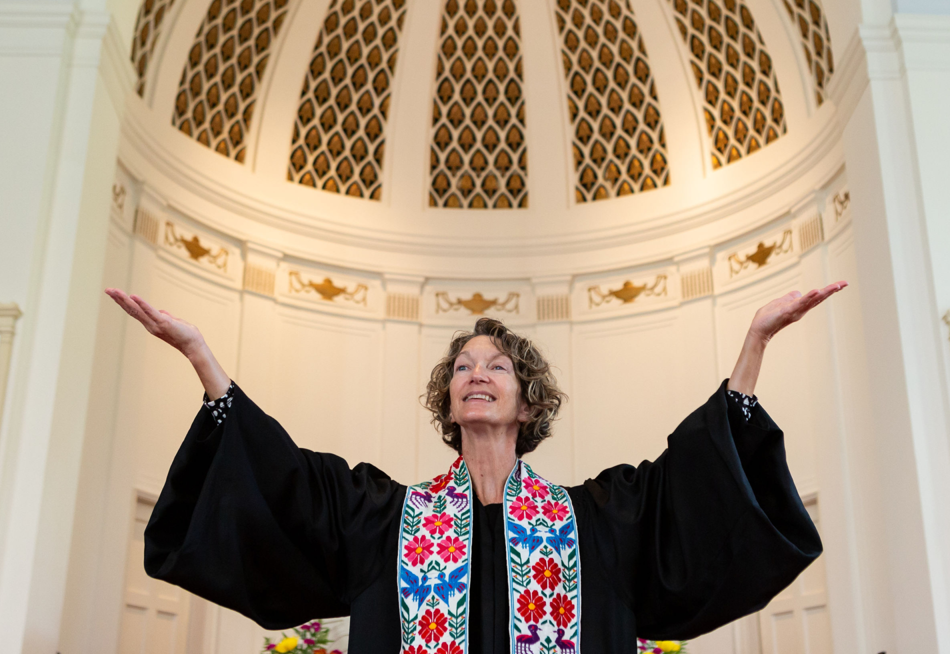 Associate Pastor Dorothy Boulton raises her arms during worship.