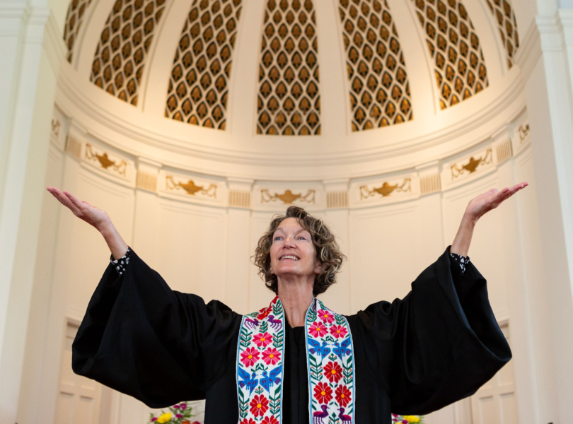 Associate Pastor Dorothy Boulton raises her arms during worship.