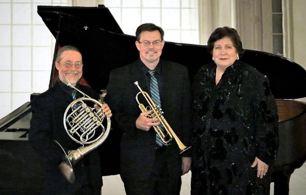 Brass Roots Trio stand with their instruments: piano, french horn, trumpet