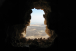 Dark cave opens to dusty landscape